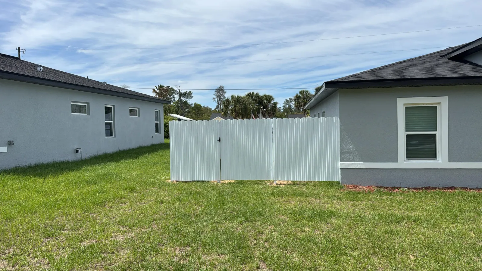 White Dura Fence with double gate between homes — Ocala FL