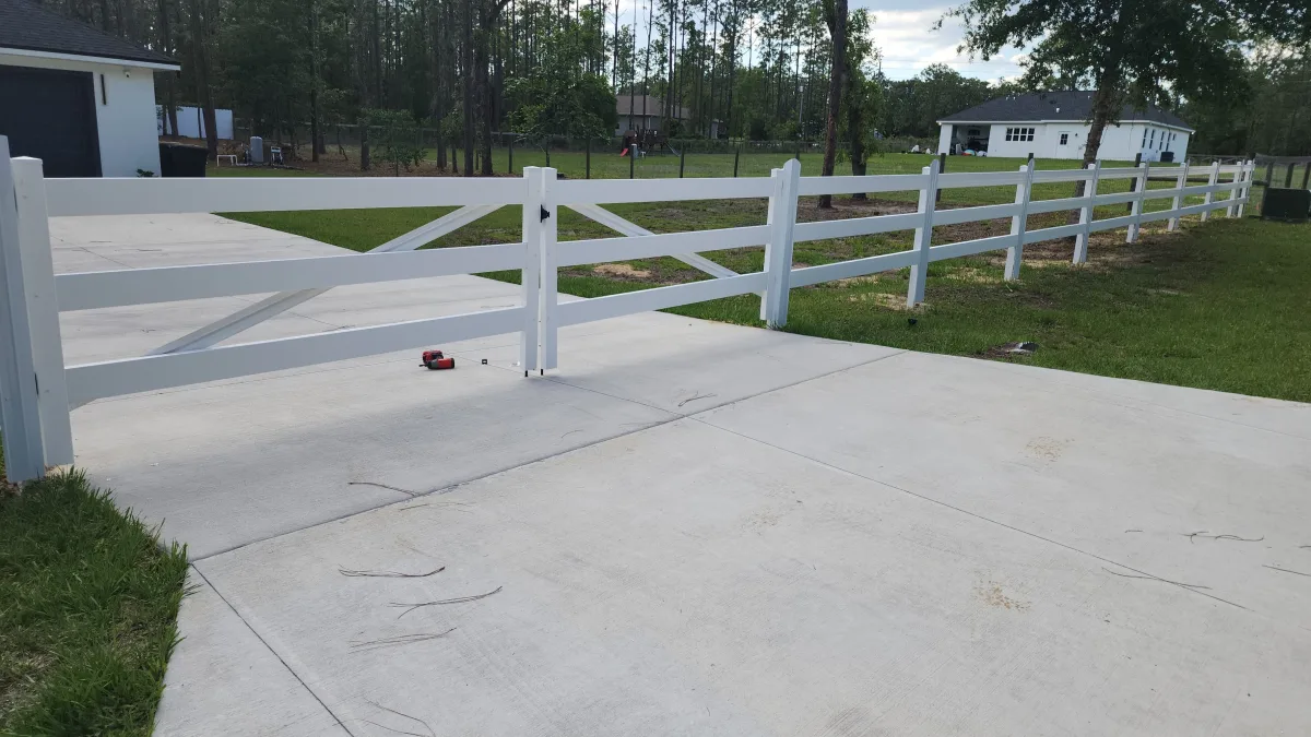 White 3-rail vinyl horse fence with X-brace driveway gate — Marion County FL