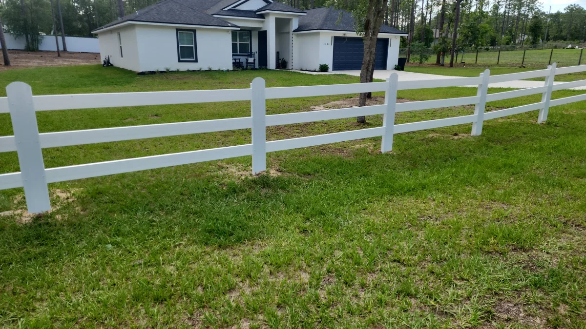 White 3-rail vinyl horse fence framing residential home — Marion County FL