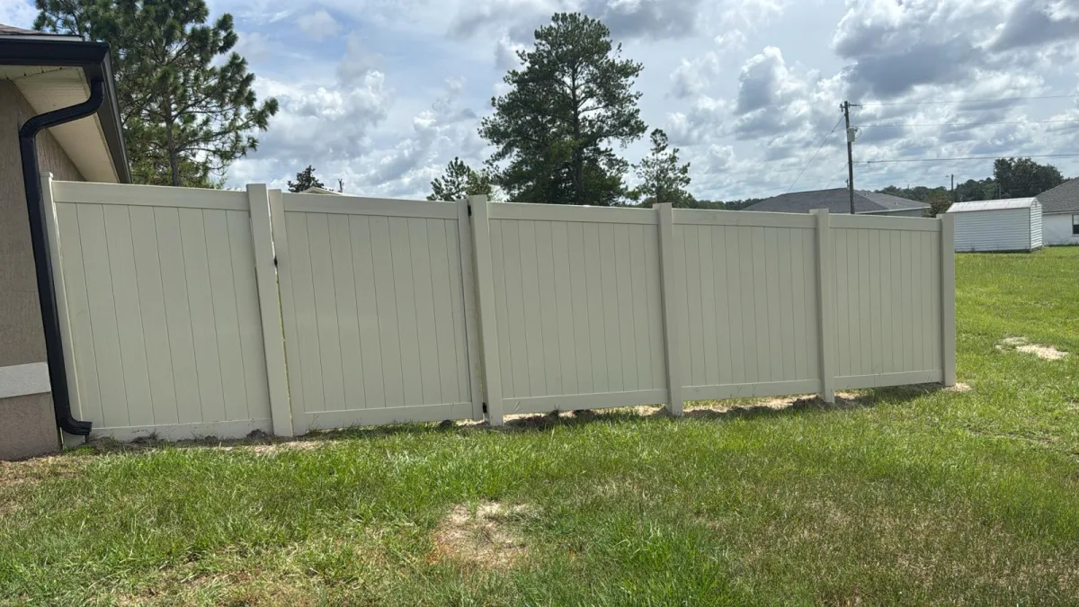 Tan cream vinyl privacy fence framing modern Florida home — Ocala FL