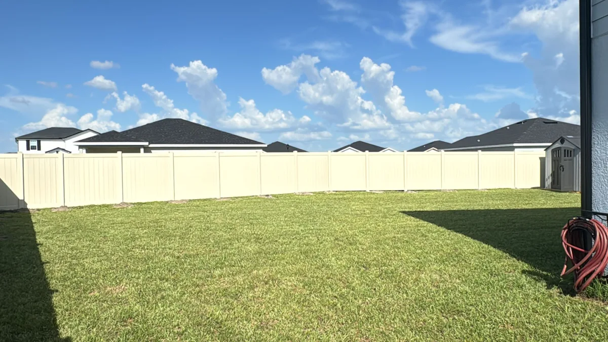 Tan cream vinyl privacy fence with shed and large yard — Marion County FL