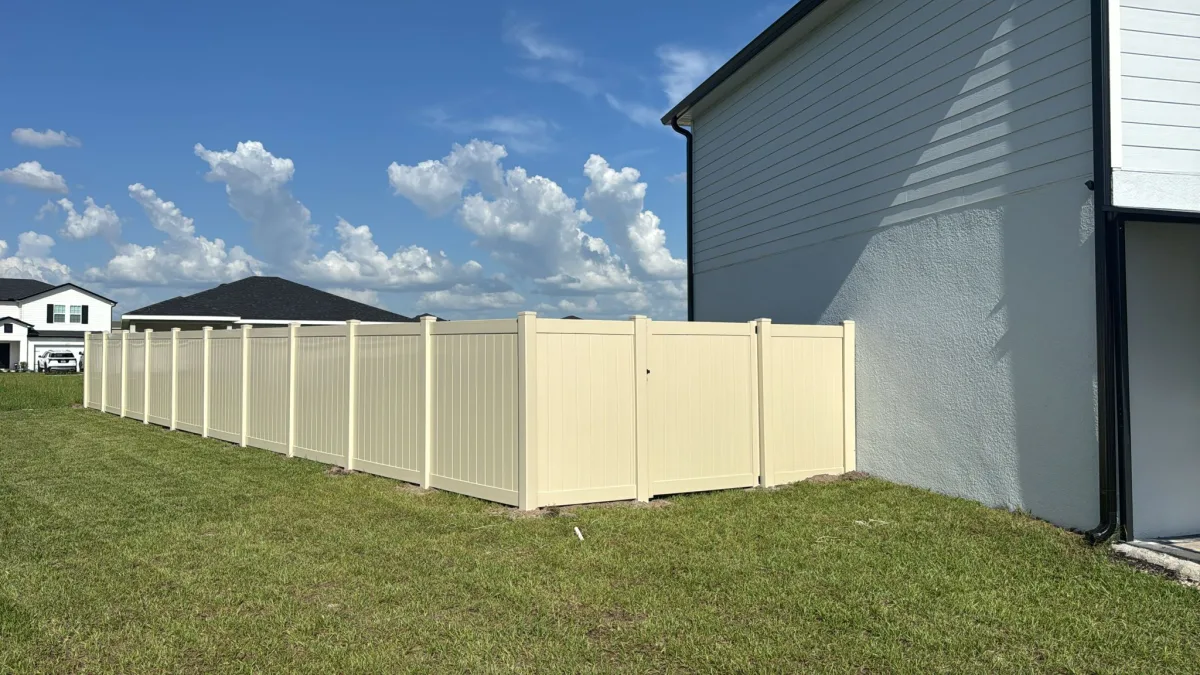 White vinyl privacy fence corner install with bright blue sky — Marion County FL