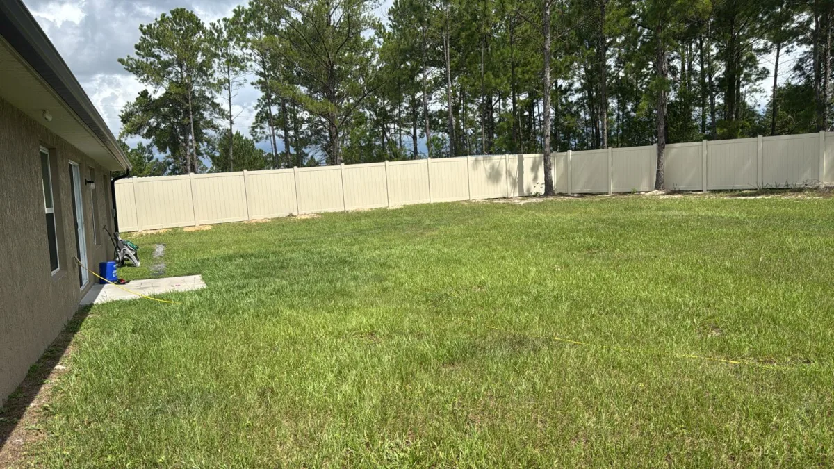 White vinyl privacy fence along front driveway with shed — Marion County FL