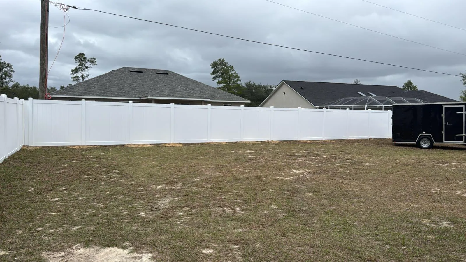 White vinyl privacy fence with double gate by Ocala Fence Install — Marion County FL