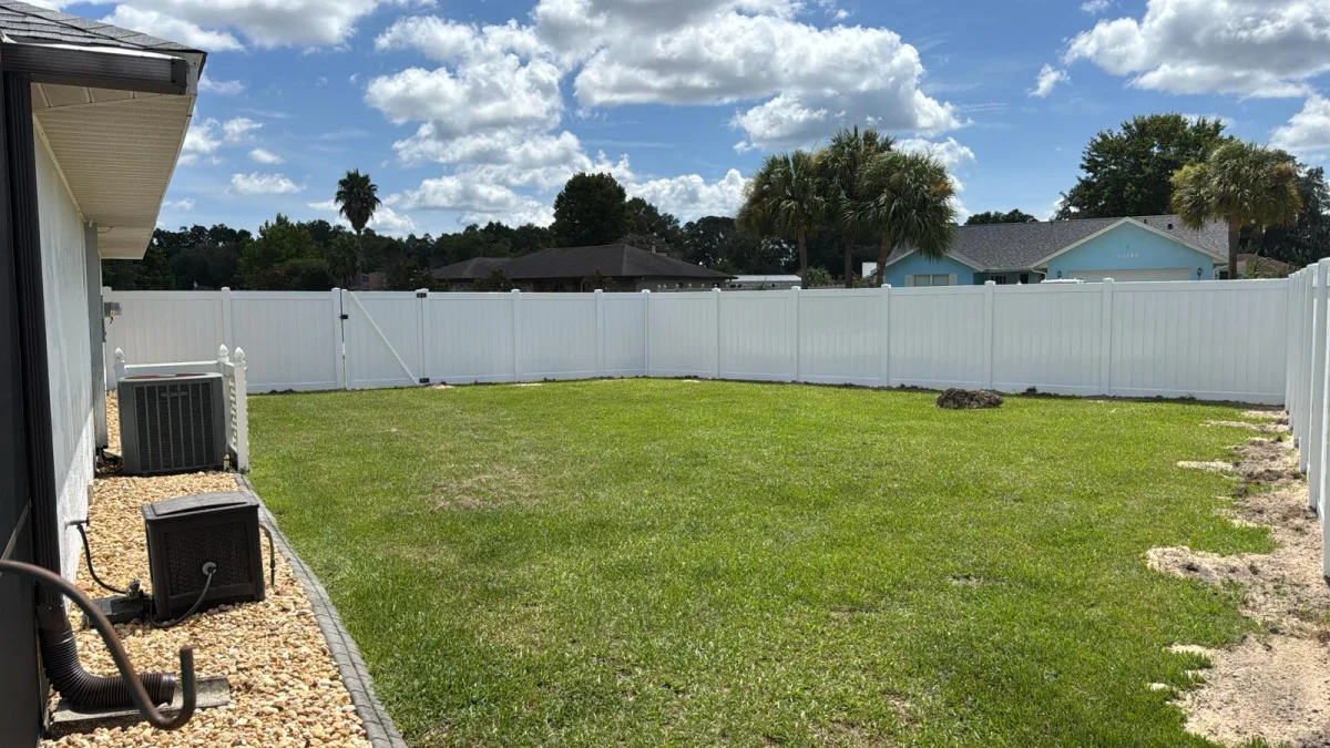 White vinyl privacy fence along property line with mature oak trees — Marion County FL